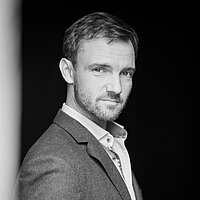 Dominik Schiefner ist Prorektor und Professor für Schauspiel und Liedgestaltung. Porträtfoto in schwarz-weiß von Prof. Dominik Schiefner.