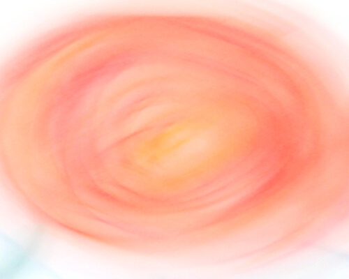 Abstraktes Bild eines verwischten, kreisförmigen Farbwirbels in warmen Rosa- und Orangetönen auf hellem Hintergrund.
