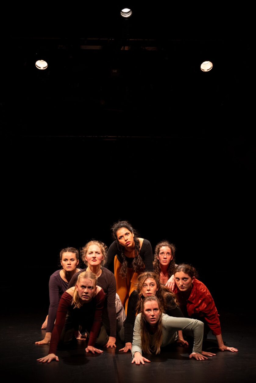 Sie sehen eine Gruppe Menschen auf einer Bühne vor dunklem Hintergrund