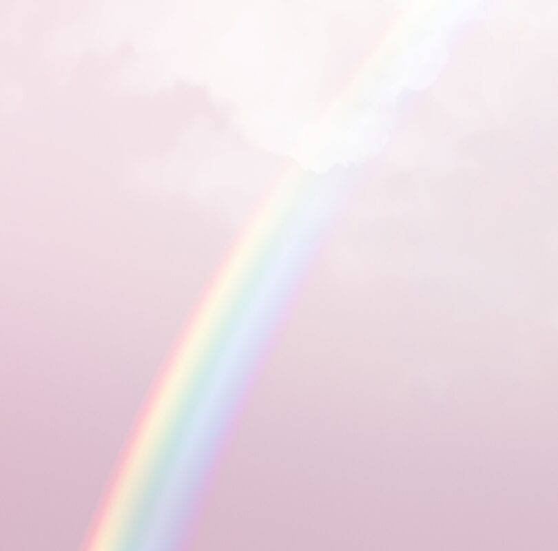 Weicher, pastellfarbener Regenbogen vor einem zart rosa Himmel mit leichten Wolken.