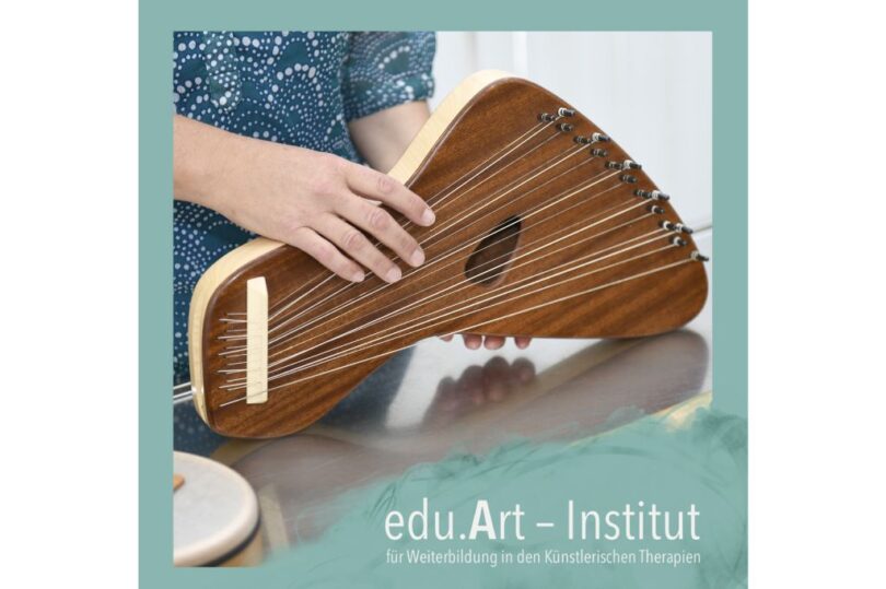 Person spielt eine kleine, dreieckige Harfe oder Kantele aus Holz mit mehreren Saiten; unten im Bild steht der Schriftzug „edu.Art – Institut für Weiterbildung