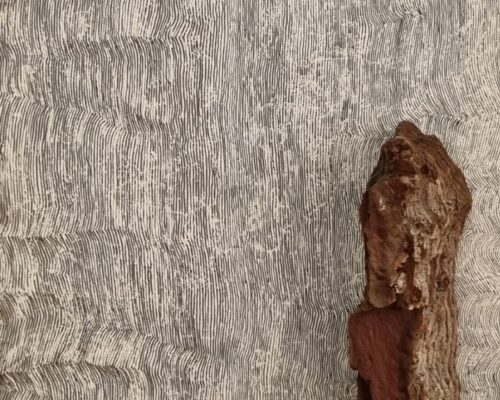 Abstraktes Foto eines Stücks brauner Rinde oder Holzes, das rechts auf einem hellen Hintergrund mit dicht verlaufenden, vertikalen Linien und leichten Wellen li