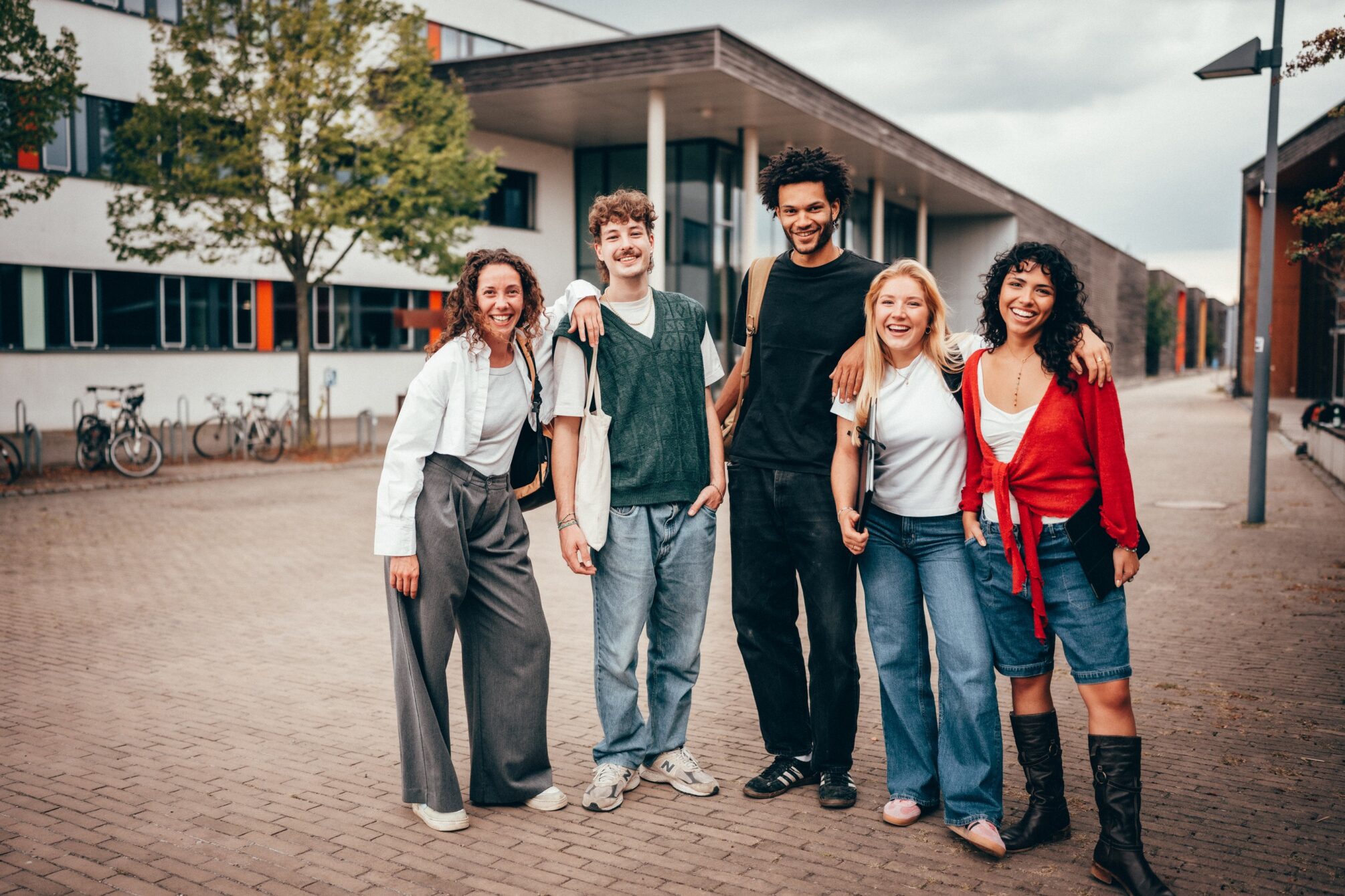 Das Bild zeigt eine Gruppe junger Menschen vor einem Gebäude.
