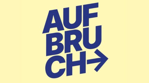 Grafik mit dem Wort „AUFBRUCH“ in großen, dunkelblauen Blockbuchstaben vor gelbem Hintergrund, ergänzt durch einen nach rechts zeigenden Pfeil.